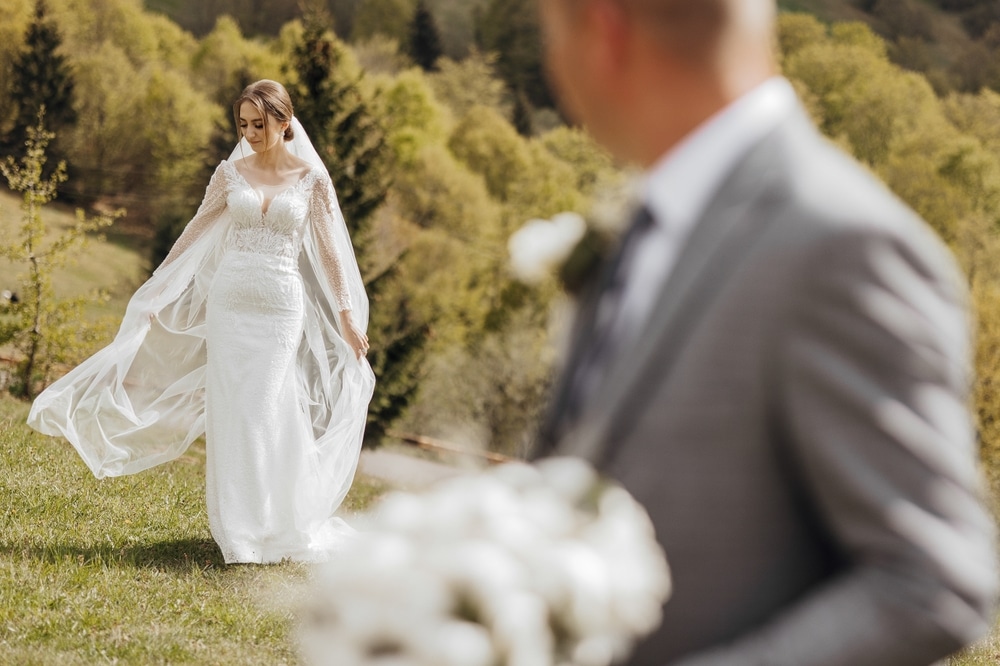 The bride is wearing a white dress and a veil, while the groom is wearing a suit. 