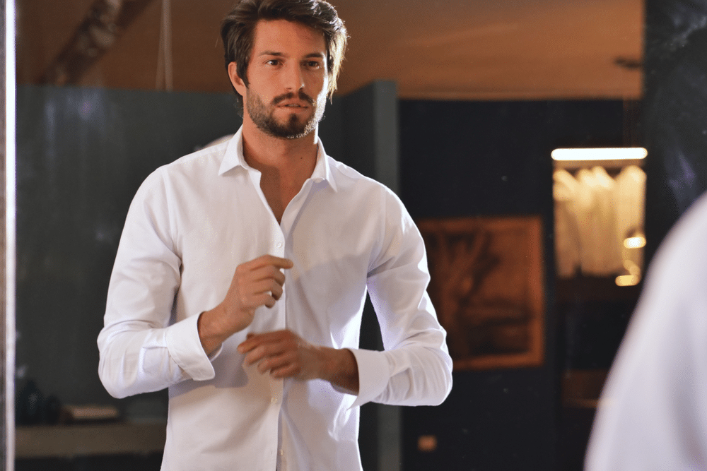 young man getting ready in his white shirt