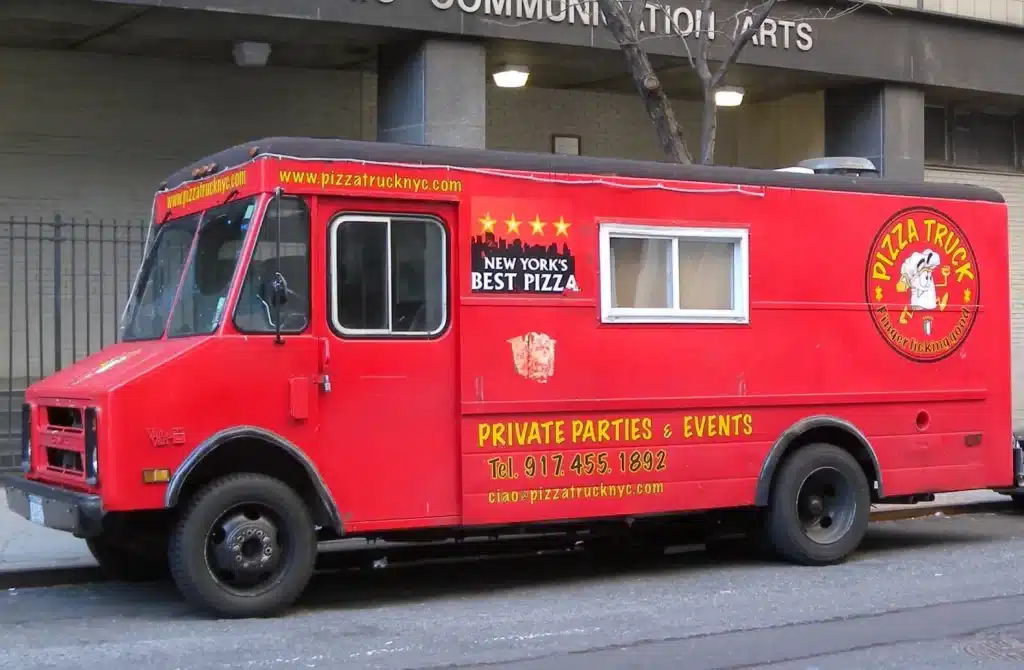 A red pizza food truck parked on road