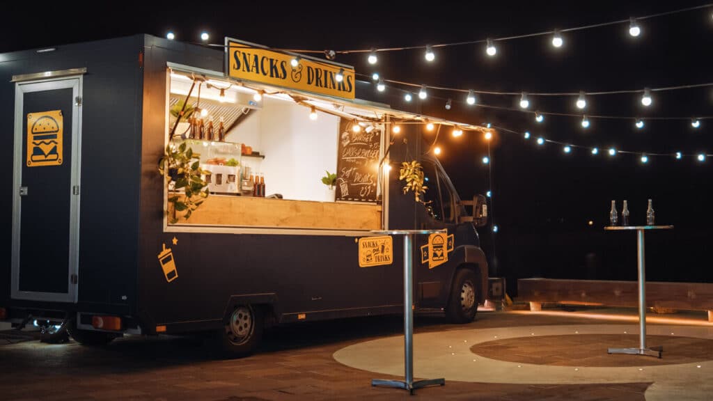 A snack food truck at night with lighting