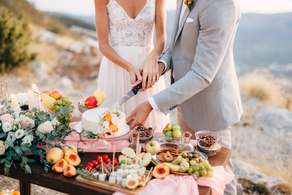 A view of a couple cutting cake at a wedding