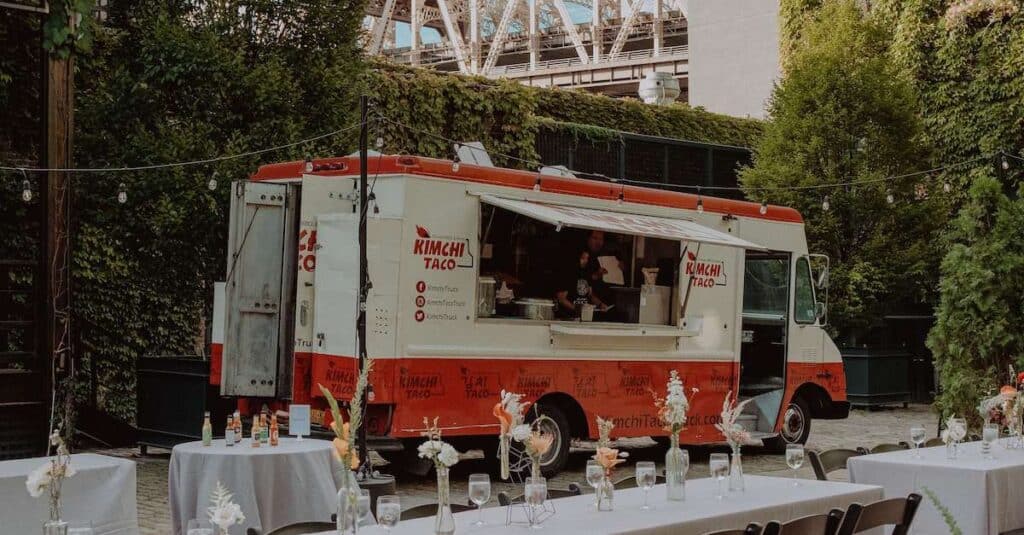 A view of an outdoor wedding food truck with table setting