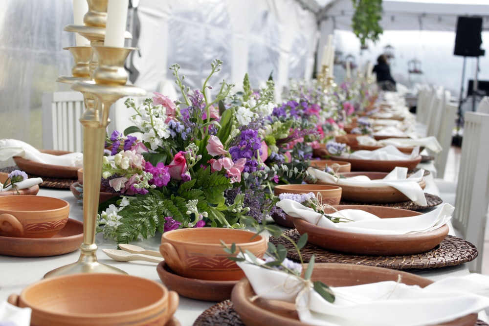 Table Setting With Terracotta Plates And Beautiful Flower Centerpiece This