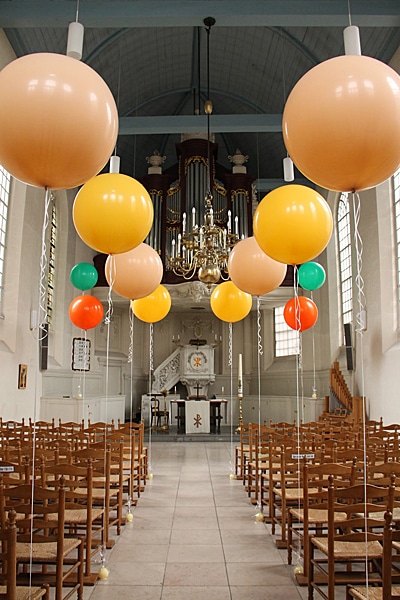 colorful ballons hung along the chairs in wedding hall