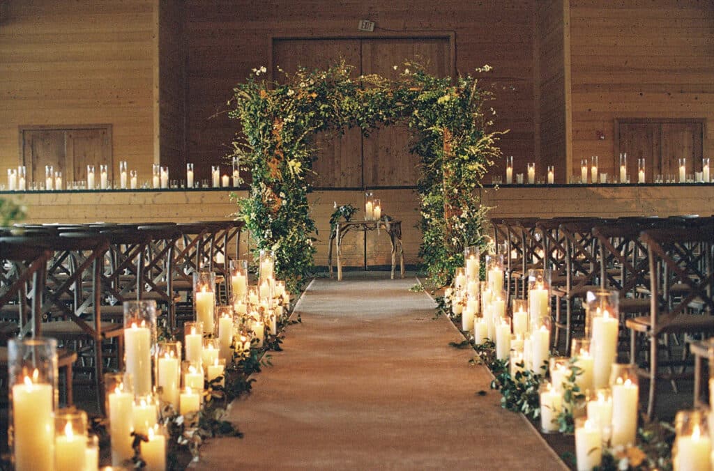 wedding aisle decorated with candles on the pathway