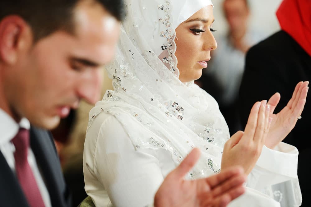 A view of a muslim couple praying at thier wedding