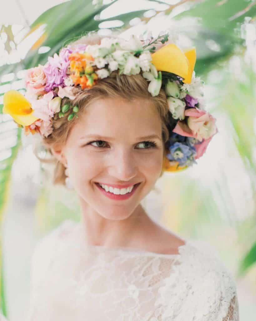 A view of a smiling bride wearing a flower crown