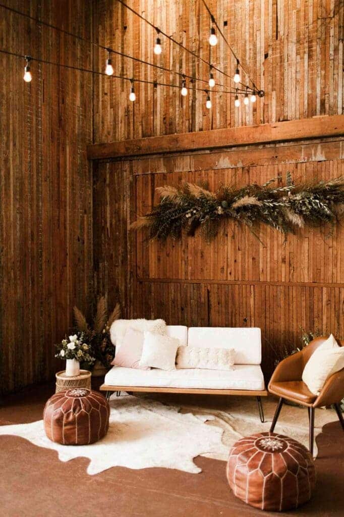 A view of a sofa seating wedding decor with a wooden rustic wall arrangement