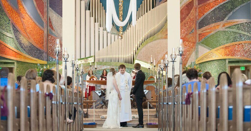 A view of an episcopal wedding taking place with people and bride and groom