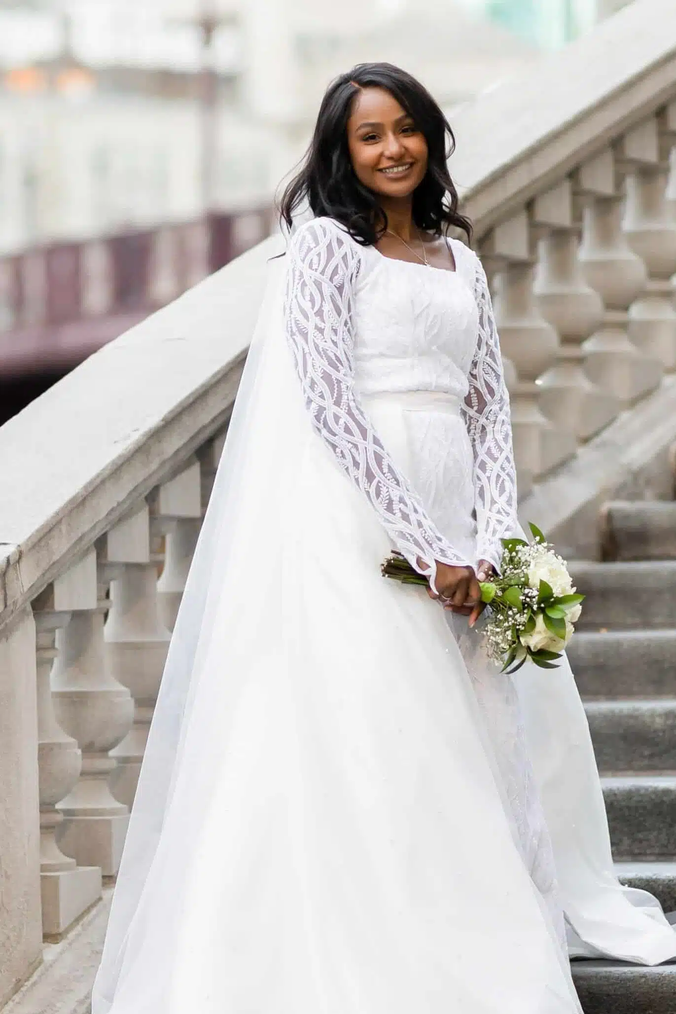 a bride is wearing long maxi along with flowers in her hand