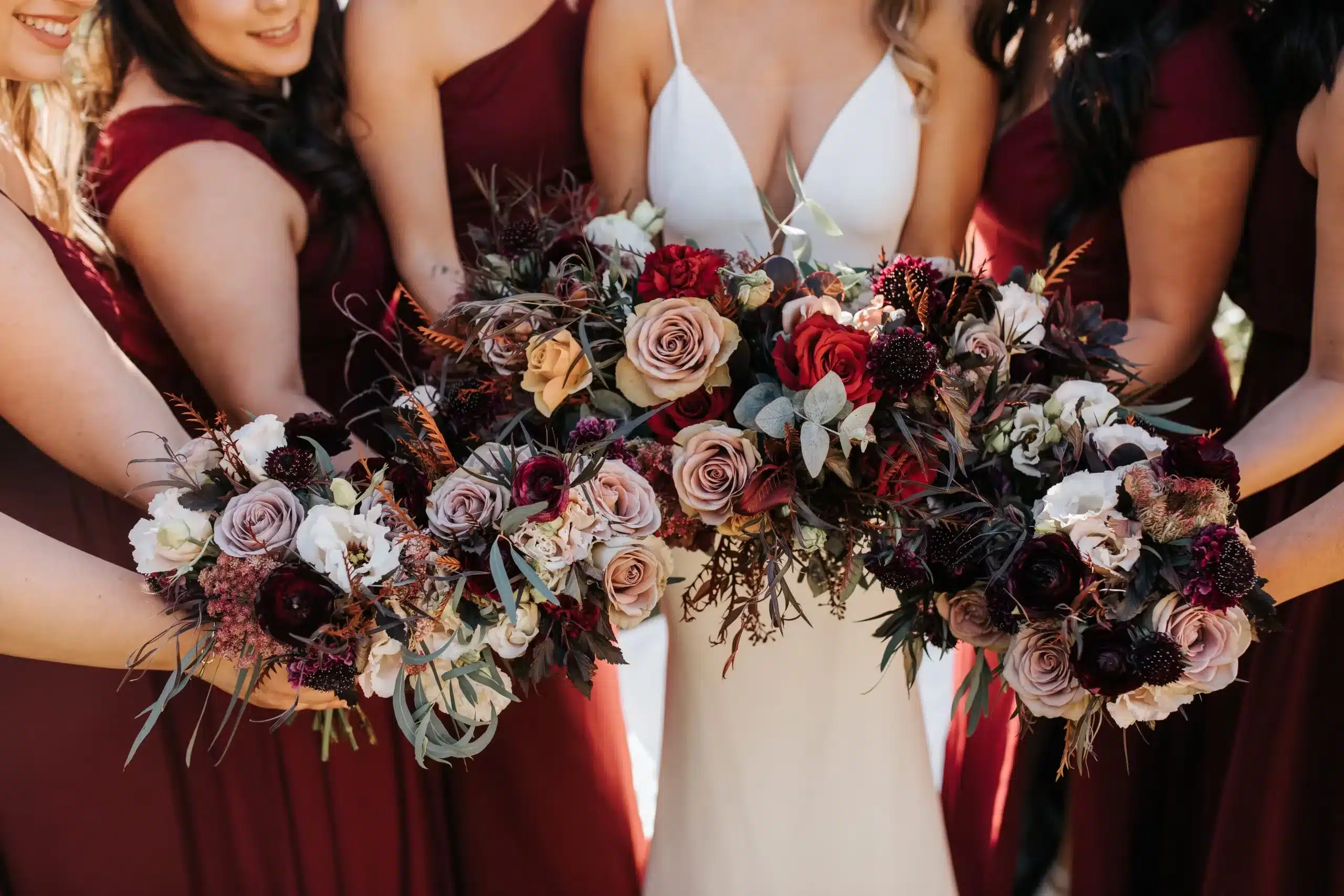 bride and bridemaids holding the fall colors flowers in their hands