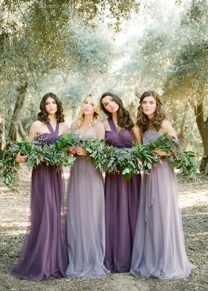 bride and bridemaids wearing purple dresses and holding flowers