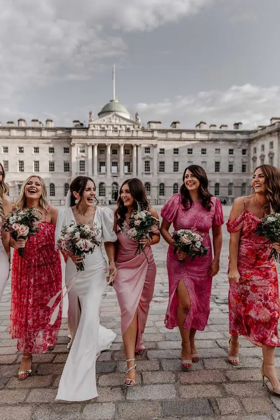 bridemaids wearing hot pink floral dresses and holding flowers