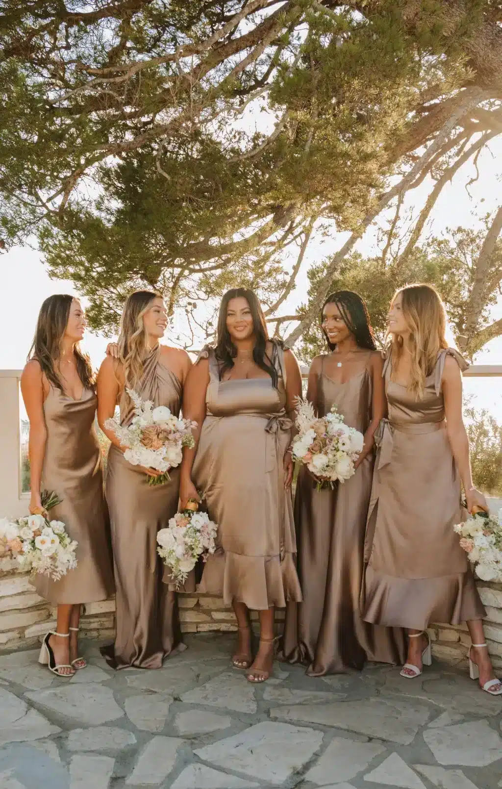 bride and bride maids wearing fall theme dresses and holding flowers in the hands 