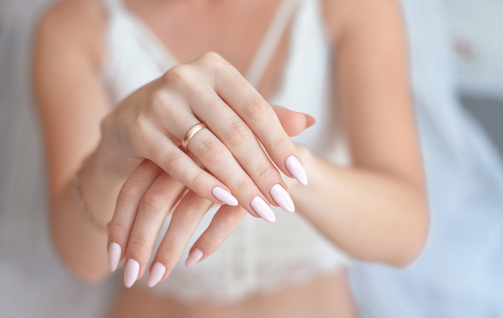 a women showing her hand along with wedding ring 