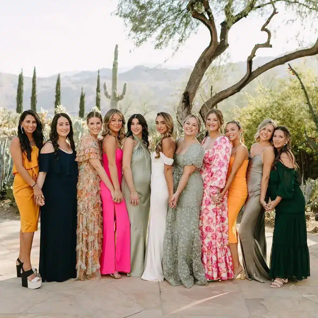 bridemaids are wearing long gowns and pose for a picture