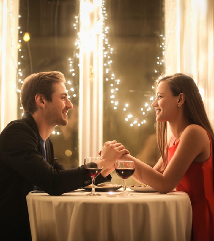 couple holding the hands at dinner table