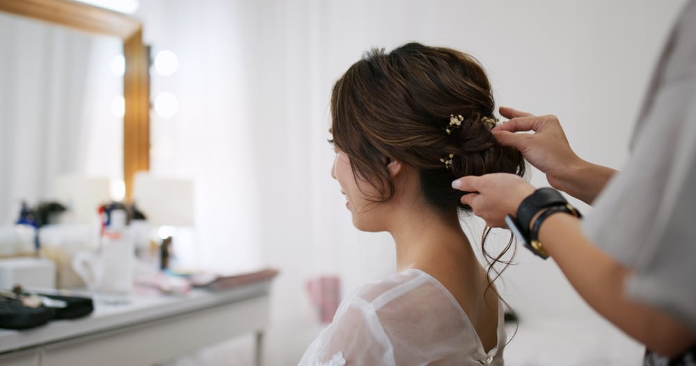 Hairdresser Creating A Hairstyle For Bride In Salon