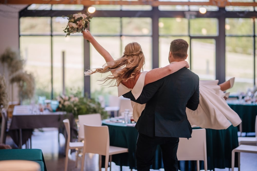 The Groom Carries The Bride In His Arms